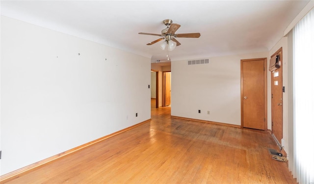 empty room featuring baseboards, visible vents, ceiling fan, and light wood finished floors