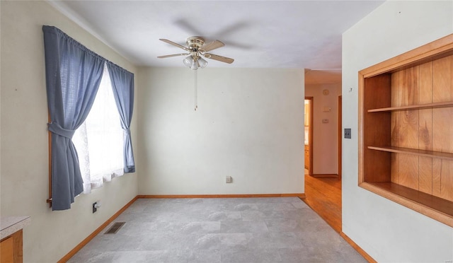 unfurnished room featuring ceiling fan, visible vents, and baseboards