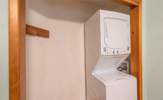 clothes washing area with stacked washer / dryer and laundry area