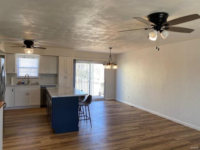 kitchen featuring dark wood-type flooring, a sink, and a healthy amount of sunlight