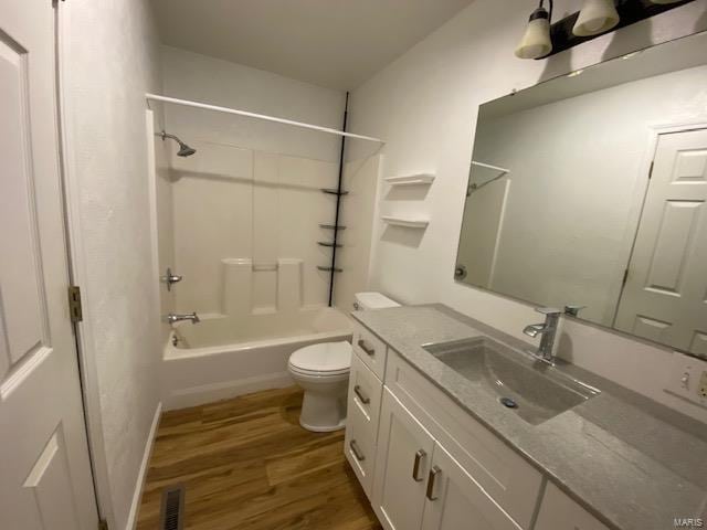 full bath with visible vents, toilet, tub / shower combination, vanity, and wood finished floors