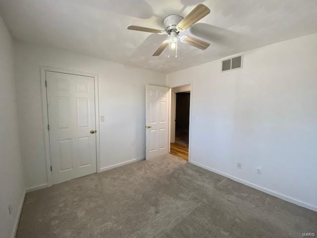 unfurnished bedroom with ceiling fan, carpet, visible vents, and baseboards