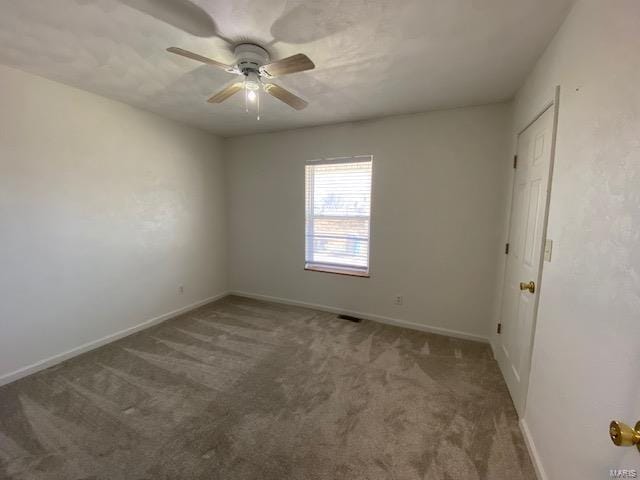 carpeted empty room featuring baseboards and a ceiling fan