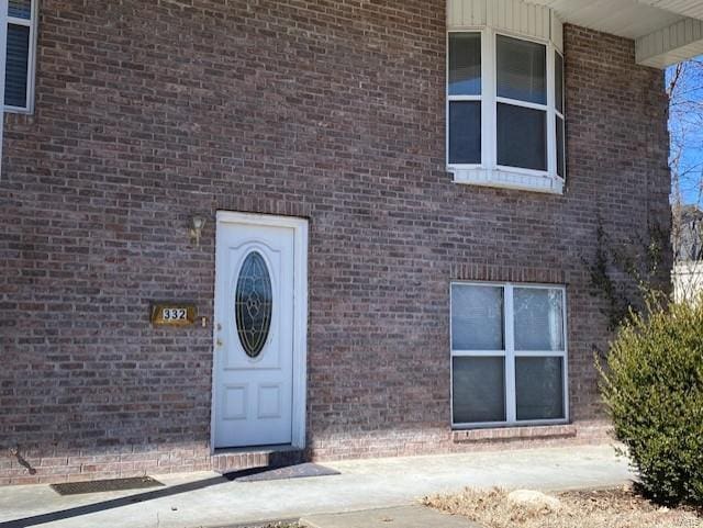 entrance to property featuring brick siding