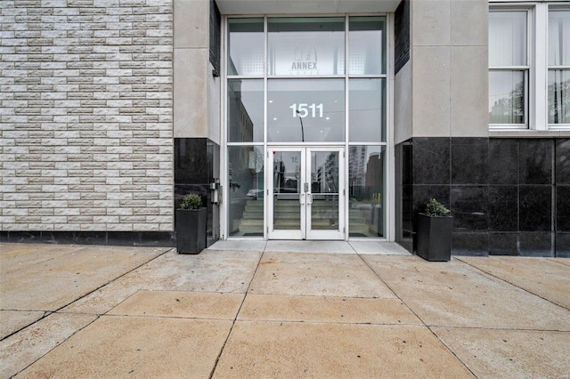 property entrance with stone siding and french doors