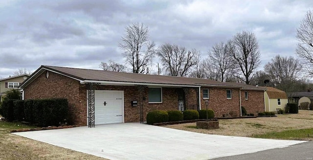 ranch-style house featuring a garage, metal roof, brick siding, and concrete driveway