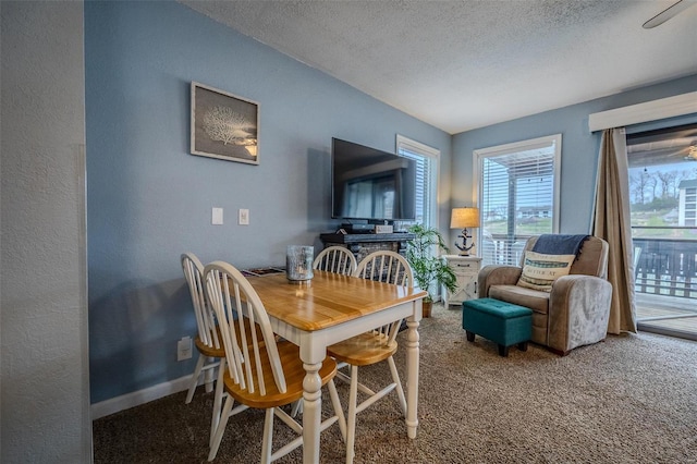 dining space featuring a textured ceiling, carpet floors, a textured wall, and baseboards