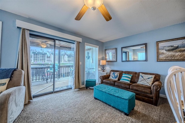 carpeted living room with ceiling fan and baseboards