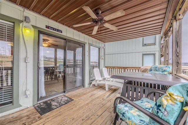 sunroom / solarium featuring wood ceiling, a ceiling fan, and a healthy amount of sunlight