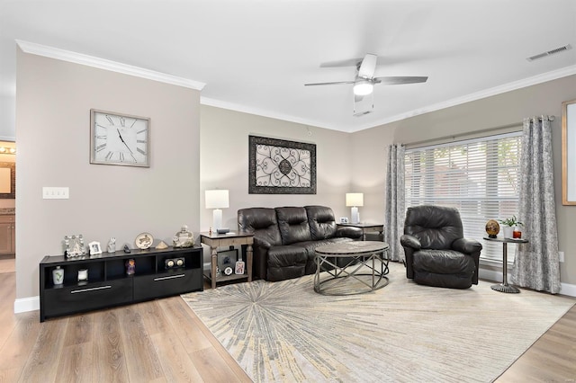 living area with visible vents, wood finished floors, and ornamental molding