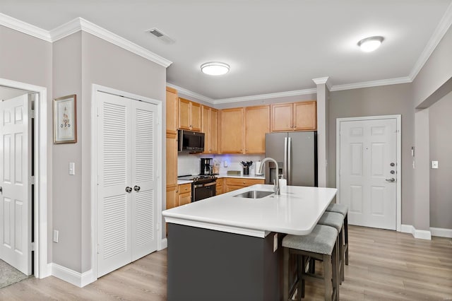 kitchen featuring light brown cabinets, a sink, visible vents, light countertops, and appliances with stainless steel finishes