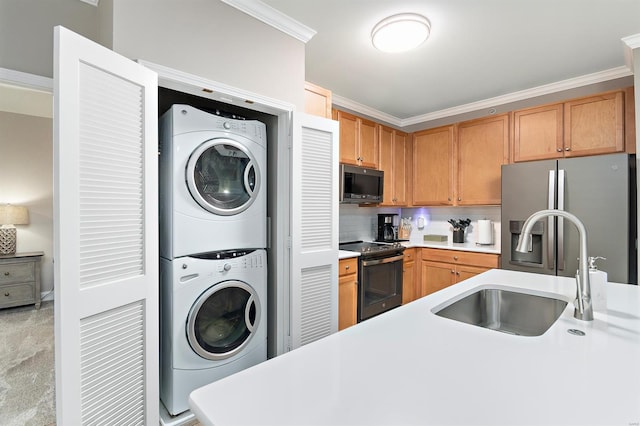 kitchen featuring stacked washer and dryer, appliances with stainless steel finishes, ornamental molding, light countertops, and a sink