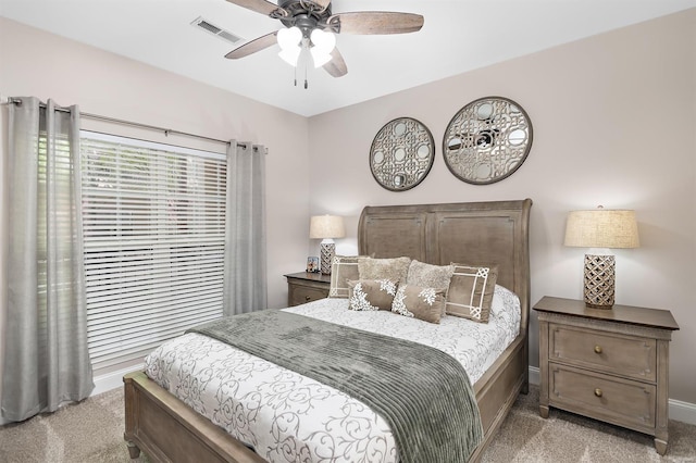 bedroom with light carpet, baseboards, visible vents, and a ceiling fan