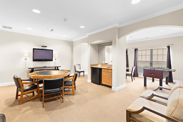 dining space featuring light colored carpet, visible vents, arched walkways, and ornamental molding