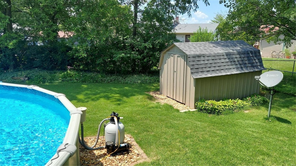 outdoor pool with a yard, a storage shed, and an outdoor structure