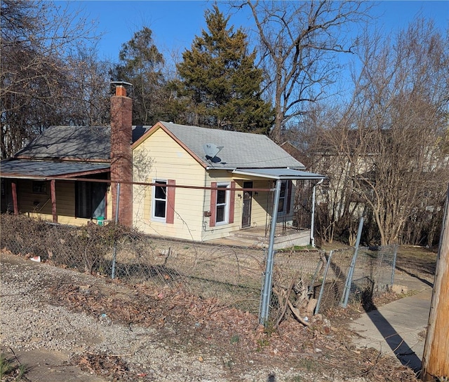 view of front of house featuring roof with shingles and a chimney