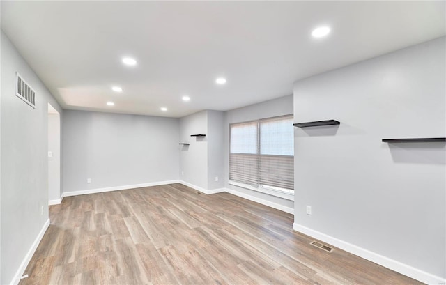 spare room with recessed lighting, visible vents, baseboards, and wood finished floors