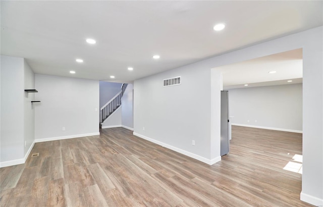 finished below grade area with stairway, wood finished floors, visible vents, and recessed lighting