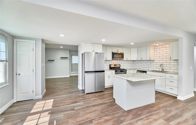 kitchen featuring appliances with stainless steel finishes, dark wood finished floors, a sink, and backsplash