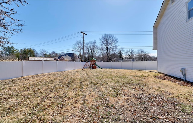 view of yard featuring a playground and a fenced backyard