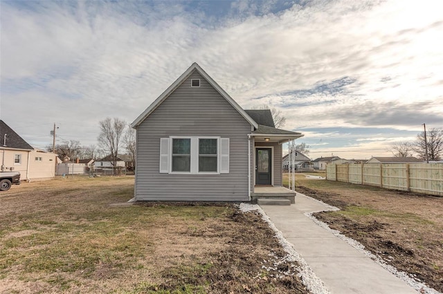 view of front of home with a front yard and fence