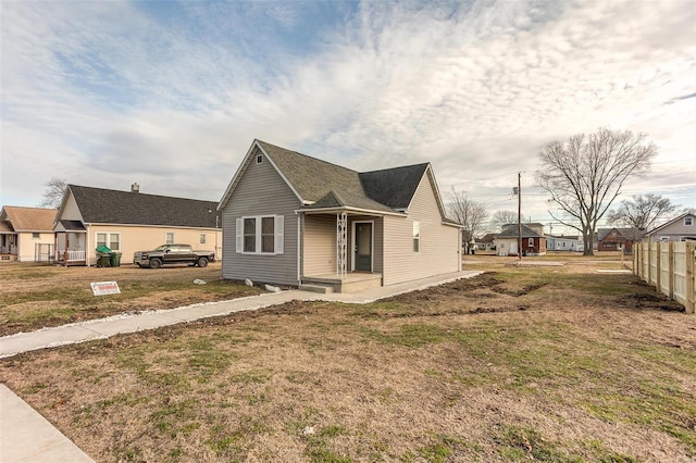 bungalow-style house with fence and a front yard