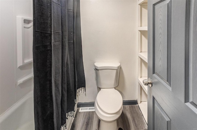 bathroom featuring toilet, baseboards, and wood finished floors