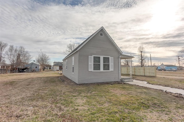 view of property exterior with a yard and fence