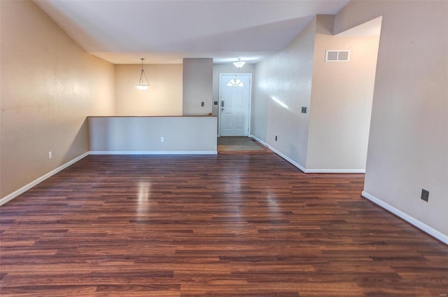 spare room with visible vents, baseboards, and wood finished floors