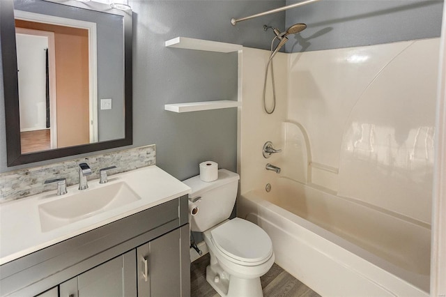 full bath with shower / bath combination, decorative backsplash, toilet, wood finished floors, and vanity