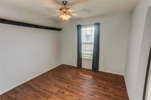 empty room with wood finished floors, a ceiling fan, and baseboards