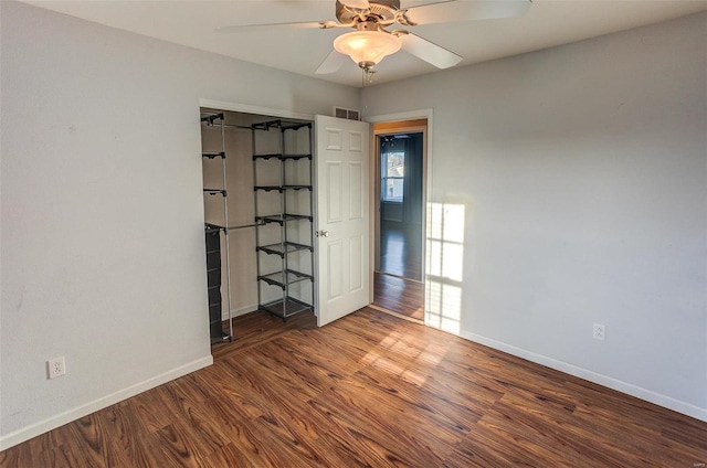 empty room with visible vents, ceiling fan, baseboards, and wood finished floors