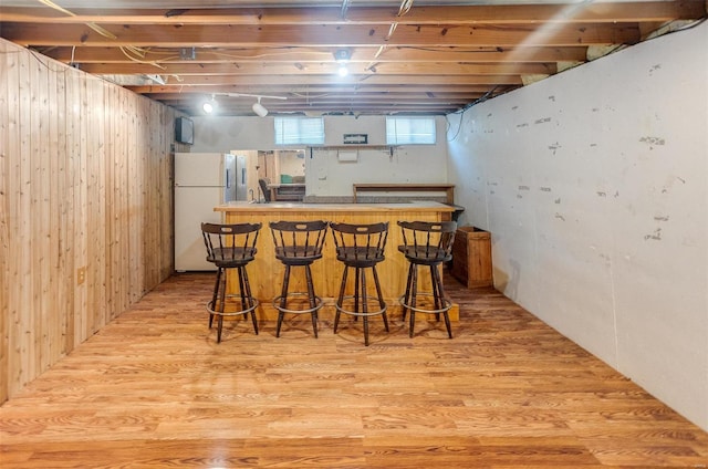 bar featuring a dry bar, light wood finished floors, and freestanding refrigerator