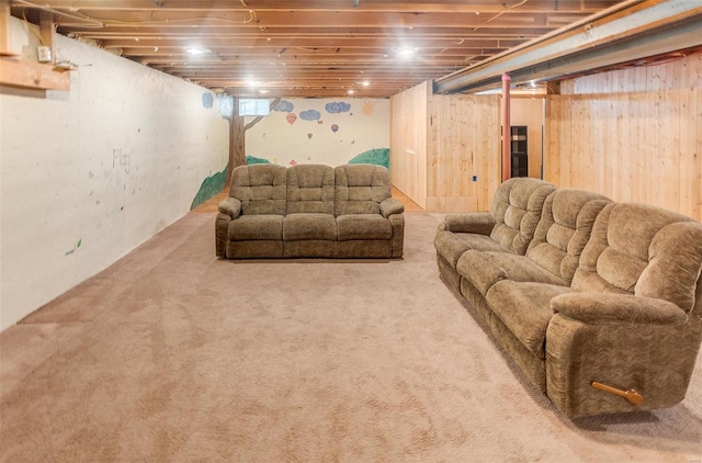 carpeted living room with wood walls