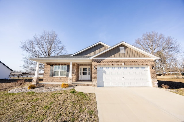 view of front of home with a porch, brick siding, an attached garage, and driveway