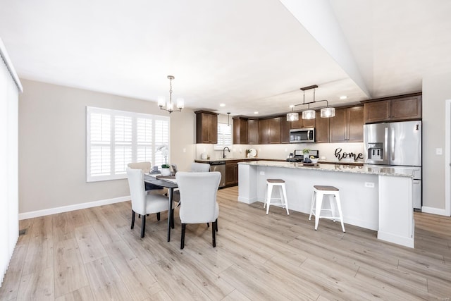 dining area featuring an inviting chandelier, recessed lighting, baseboards, and light wood-style floors