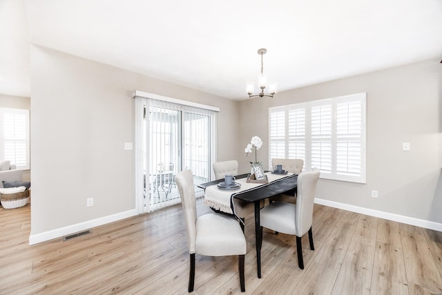 dining space with a chandelier, visible vents, baseboards, and light wood-style floors