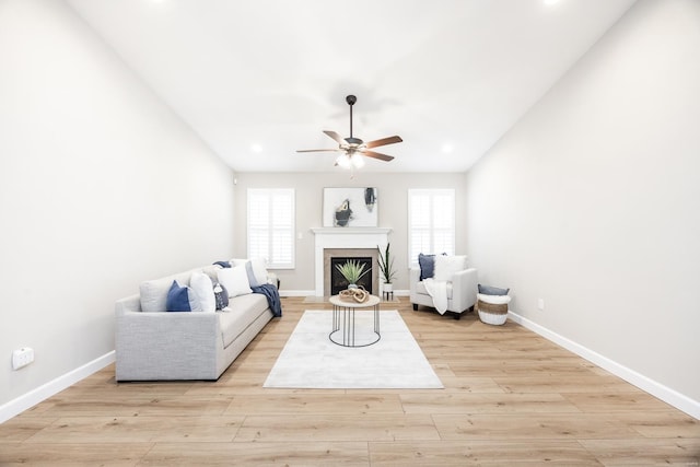 living room with a fireplace, vaulted ceiling, wood finished floors, and baseboards