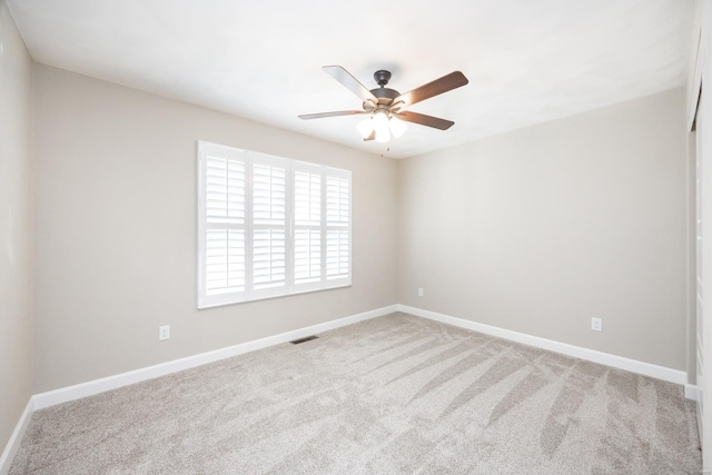 empty room featuring light carpet, visible vents, and baseboards