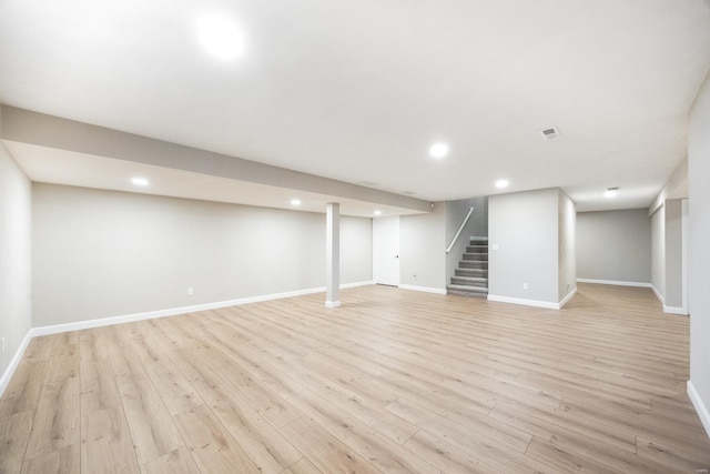 finished basement with stairway, recessed lighting, visible vents, and light wood-type flooring