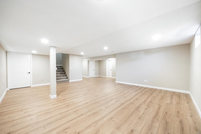 finished below grade area featuring stairway, recessed lighting, baseboards, and light wood-style floors