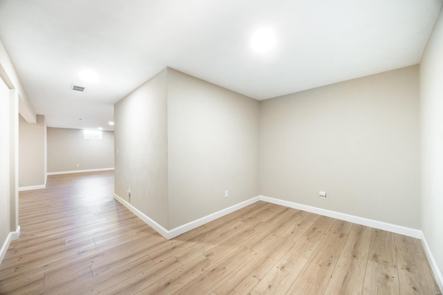 unfurnished room featuring light wood finished floors, visible vents, and baseboards