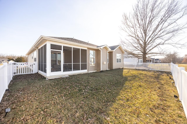 back of property featuring a yard, a fenced backyard, and a sunroom