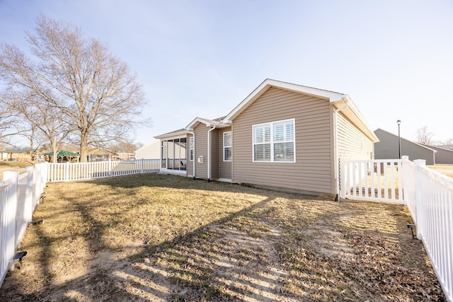 rear view of house featuring a lawn and a fenced backyard