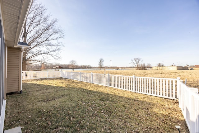 view of yard featuring a rural view and a fenced backyard