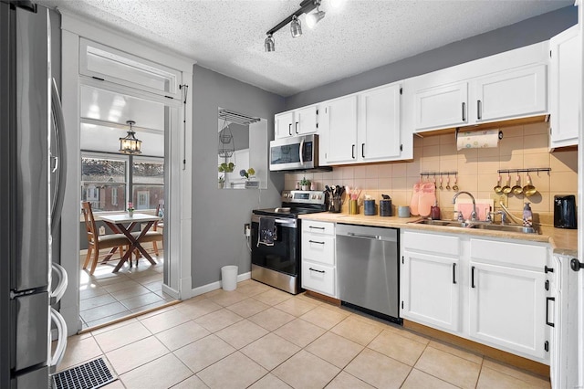 kitchen with light tile patterned floors, stainless steel appliances, a sink, and light countertops