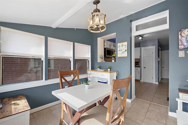 dining space featuring a chandelier, vaulted ceiling with beams, light tile patterned flooring, and baseboards