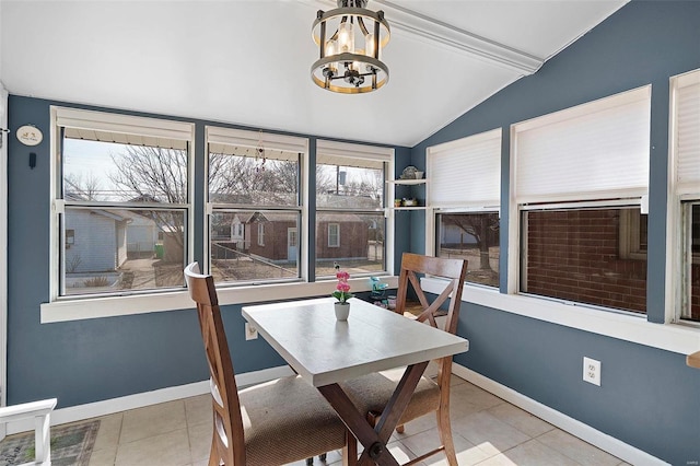 dining area featuring tile patterned flooring, vaulted ceiling, baseboards, and an inviting chandelier