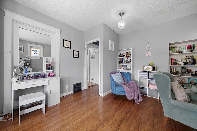 office with a textured ceiling, baseboards, and wood finished floors