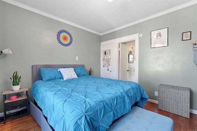 bedroom with crown molding, a textured ceiling, baseboards, and wood finished floors